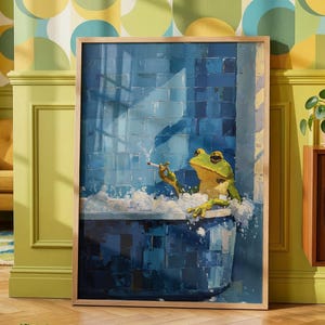 May include: A framed rectangular wall art print featuring a green frog sitting in a blue tiled bathtub filled with white soap bubbles. The frog is holding a lit cigarette in one hand. The artwork uses a painterly style with visible brushstrokes.