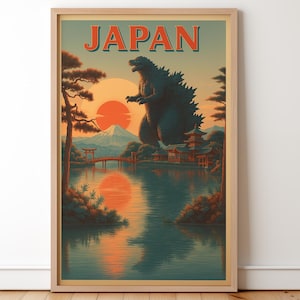 May include: Framed art print featuring a vintage-style illustration of Japan. The artwork depicts Godzilla towering over a lake with a bridge, pagodas, and Mount Fuji at sunset. The word "JAPAN" is at the top.