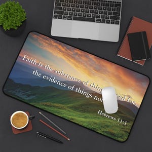 May include: A desk mat with a scenic landscape image of a mountain range at sunset. The text "Faith is the substance of things not seen, Hebrews 11:1" is printed on the mat.