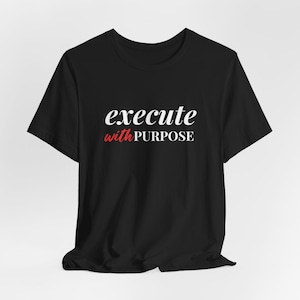 May include: Black t-shirt with white text that reads "execute with PURPOSE" in a cursive font. The word "PURPOSE" is in red.