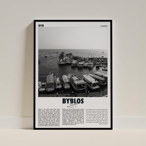 May include: Monochrome framed print depicting a harbor with many boats. The print includes the word "BYBLOS" in large letters and text in English and Arabic. The print is labelled "Lebanon".