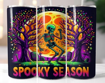 Könnte beinhalten: Ein Set aus drei Edelstahlbechern mit einem gruseligen Halloween-Design. Die Becher zeigen ein Skelett, das vor einem Vollmond mit Bäumen und Grabsteinen tanzt. Der Text "Spooky Season" ist auf der Unterseite der Becher aufgedruckt.