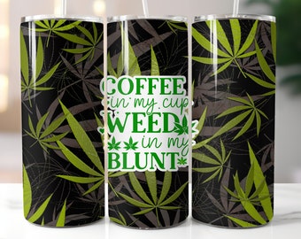 Puede incluir: Un vaso de acero inoxidable con una pajita blanca. El vaso presenta un fondo negro con un patrón de hojas de cannabis verdes y marrones. El texto "COFFEE in my cup WEED in my BLUNT" se muestra en verde.