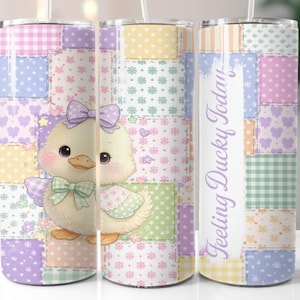 May include: A stainless steel tumbler with a patchwork design in pastel colours. The tumbler features a cartoon duck with a bow and the text "Feeling Ducky Today". The tumbler has a straw.