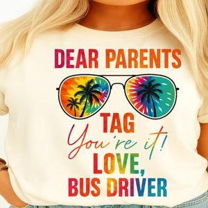 Puede incluir: Una camiseta blanca con el texto "Dear Parents Tag You're It! Love, Bus Driver" y unas gafas de sol de color tie-dye arcoíris con palmeras reflejadas en las lentes.