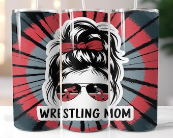 May include: A stainless steel tumbler with a red, black, and gray tie-dye pattern. The tumbler features a graphic of a woman with a messy bun, sunglasses, and the text "WRESTLING MOM".