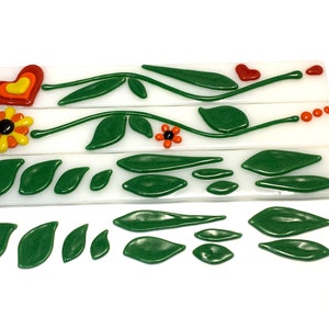 May include: Three white tiles with green leaves, vines, and flowers in shades of red, orange, and yellow. A separate set of green leaves are arranged below the tiles.