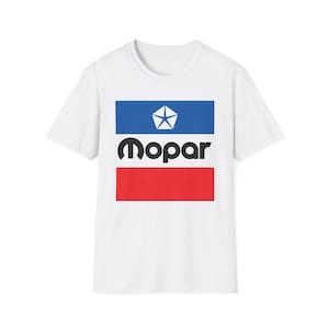 Könnte beinhalten: Weißes T-Shirt mit dem Mopar-Logo. Das Design zeigt ein blaues Rechteck mit einem weißen Stern, das schwarze Wort "Mopar" und ein rotes Rechteck. Das T-Shirt hat kurze Ärmel und einen Rundhalsausschnitt. Das Design ist mittig platziert.