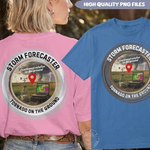 May include: A pink t-shirt and a blue t-shirt, each featuring a circular graphic with the text STORM FORECASTER and TORNADO ON THE GROUND. The graphic depicts a laptop displaying a weather radar, a tripod, and a red location pin icon.