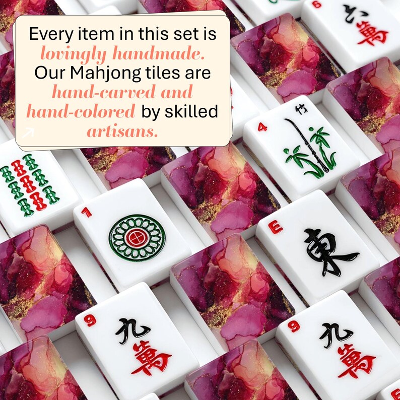 May include: A collection of Mahjong tiles featuring white surfaces with black, red, and green ink symbols and backs with a pink, purple, and gold marbled pattern. Text on the image reads: Every item in this set is lovingly handmade. Our Mahjong tiles are hand-carved and hand-colored by skilled artisans.