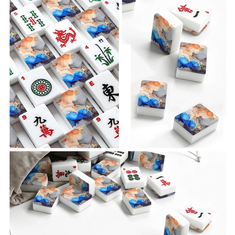 May include: A collection of rectangular mahjong tiles featuring white faces with traditional red, green, and black character markings, and backs decorated with a swirling abstract pattern of blue, orange, and gold ink-like colors.