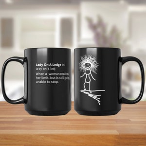May include: Black coffee mug with a white design. The design features a stick figure woman standing on a ledge with the text "Lady On A Ledge (n.) la-dy 'on 'a 'ledj When a woman reaches her limit, but is still going unable to stop."