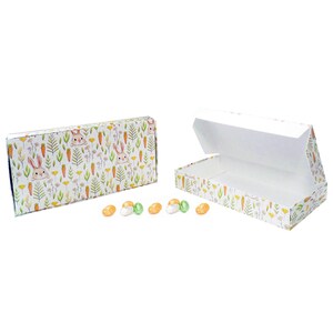 May include: Two rectangular Easter-themed boxes, one open, with a bunny and floral pattern. The boxes are white with a colorful design of bunnies, carrots, and flowers. Several jelly beans in various colors are scattered in front of the boxes.