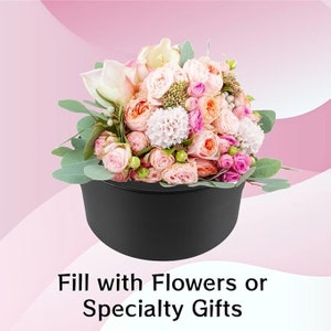 May include: A black container overflowing with a colourful arrangement of pink, peach, and white flowers, with green foliage. The text at the bottom reads "Fill with Flowers or Specialty Gifts."