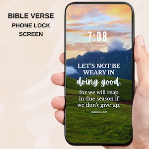 May include: A smartphone displays a lock screen with a scenic landscape of green hills and mountains under a sunset sky. The screen features the text "LET'S NOT BE WEARY IN doing good" and a Bible verse.