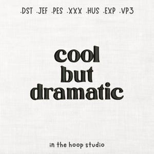 May include: White fabric with the words "cool but dramatic" embroidered in black, bold letters. The phrase is centered, with "cool" at the top, "but" in the middle, and "dramatic" at the bottom. Below the phrase is "in the hoop studio".