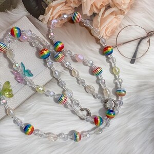 May include: A rainbow striped beaded phone chain with clear beads and butterfly charms.