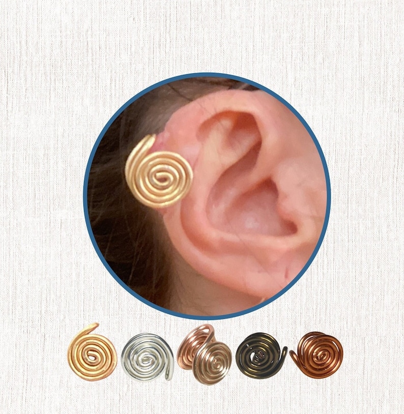 Photo of a person’s ear with a golden wire spiral cuff clipped onto the edge. Five wire spiral earcuffs are shown below in gold, silver, rose gold, dark bronze and dark copper colours.