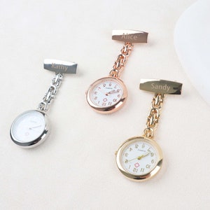 May include: Three pocket watches with chains and personalised name tags. The watches are gold-tone, silver-tone, and rose gold-tone. The name tags read "Kathy", "Alice", and "Sandy".