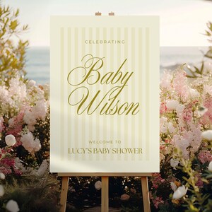 Printable yellow baby shower sign in classic striped design, shown at the entrance of a gender-neutral baby shower — editable Canva file in A0 format for easy customization.