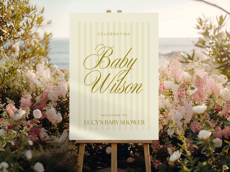 Printable yellow baby shower sign in classic striped design, shown at the entrance of a gender-neutral baby shower — editable Canva file in A0 format for easy customization.
