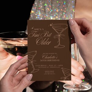 Modern brown cocktail-themed Tini Bit Older birthday invitation with martini glasses, editable 5x7 Canva template for espresso martini lovers’ parties.