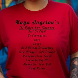 May include: Red t-shirt with black text that reads "Maya Angelou's 10 Rules For Success" and lists the rules: "Just Do Right", "Be Courageous", "Love", "Laugh", "Be A Blessing To Somebody", "Turn Struggle Into Triumph", "Recognize Your Talent", "Learn To Say NO", "Always Do Your Best", and "Keep Rising".