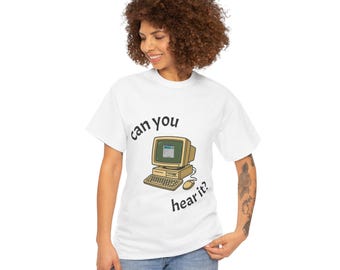 以下が含まれることがあります： 「can you hear it?」のテキストとレトロなコンピューターグラフィックが特徴の白いTシャツ。ベージュのコンピューターモニター、キーボード、マウスのデザイン。カジュアルウェアです。