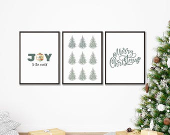 May include: Three framed Christmas art prints. One print says "Joy to the world" with a decorative ornament. The second print features nine stylized Christmas trees. The third print says "Merry Christmas" in cursive.
