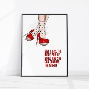 May include: A framed print featuring a fashion illustration of red high-heeled shoes with a platform sole. The shoes are paired with white polka-dot socks. The text reads: "GIVE A GIRL THE RIGHT PAIR OF SHOES AND SHE CAN CONQUER THE WORLD."