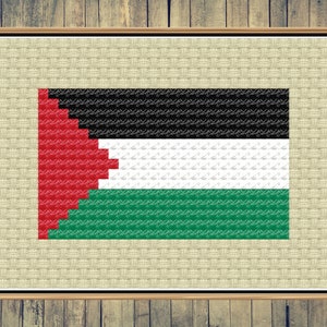 May include: A framed cross-stitch of the Palestinian flag. The flag is red, black, white, and green. The red triangle is on the hoist side of the flag. The black, white, and green stripes are horizontal.
