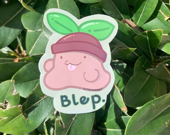 May include: A green, brown, and pink cartoon sticker of a creature with a sprout on its head. The sticker says "Bleep." and "Cutesoupart" in the bottom right corner.