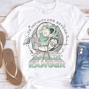 Puede incluir: Camiseta blanca con un gr&aacute;fico de estilo vintage de Buzz Lightyear de Toy Story. El gr&aacute;fico presenta a Buzz en su traje de ranger espacial con el texto "To Infinity and Beyond" y "Space Ranger".