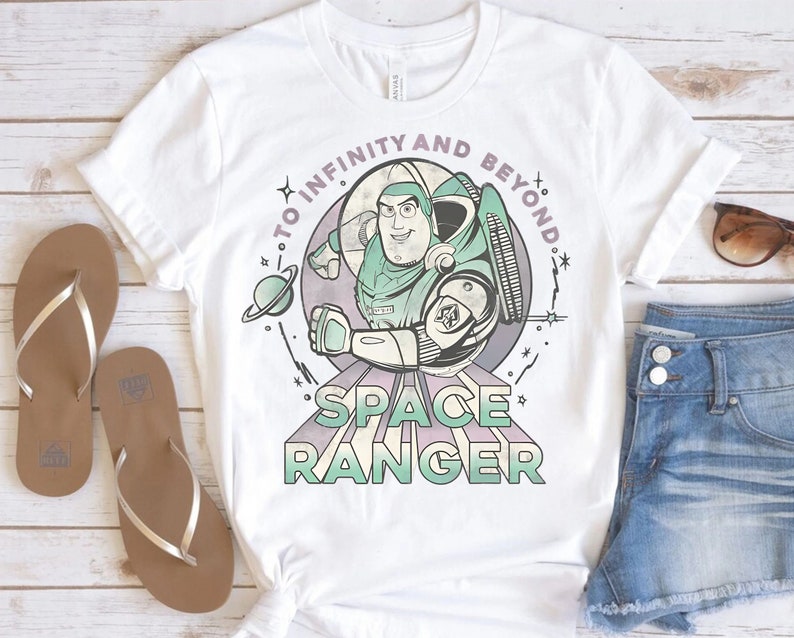 Puede incluir: Camiseta blanca con un gr&aacute;fico de estilo vintage de Buzz Lightyear de Toy Story. El gr&aacute;fico presenta a Buzz en su traje de ranger espacial con el texto "To Infinity and Beyond" y "Space Ranger".
