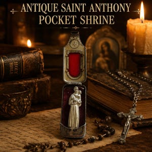 Puede incluir: Antiguo relicario de bolsillo de San Antonio, abierto para revelar una estatua plateada de un santo sosteniendo a un niño, sobre un fondo de terciopelo rojo. La caja con bisagras es plateada. La imagen incluye un rosario, una vela y el texto "ANTIQUE SAINT ANTHONY POCKET SHRINE."