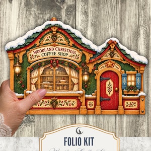 Puede incluir: Un kit de folio imprimible Woodland Christmas Coffee Shop con una ilustración detallada de un edificio festivo con puerta roja, paredes verdes, techo cubierto de nieve y un escaparate con pasteles y artículos de café.