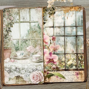 May include: A vintage-style journal with a floral and window design. The open pages display a tea setting and a window scene with pink orchids. The journal has a distressed, aged appearance, with scissors and a key on the wooden surface.