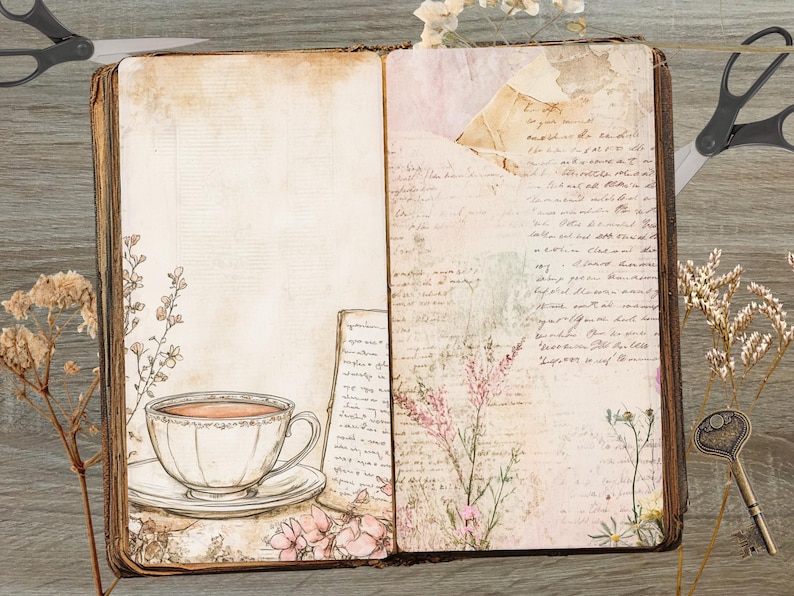 May include: Open vintage journal with aged paper pages. A teacup and saucer are on the left page, with floral and script details. The right page has script and floral elements. Dried flowers and a key are on the wooden surface.