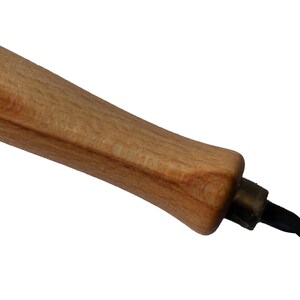 May include: A woodworking tool with a light brown wooden handle and a black, twisted metal drill bit. The handle is smooth and ergonomic, designed for a comfortable grip. The tool is likely used for drilling holes in wood.