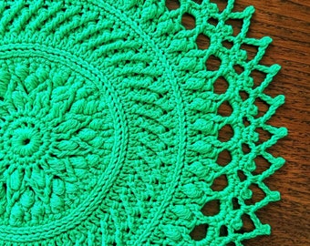 Crocheted emerald green doily, with embossed motifs