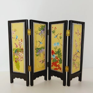 May include: A four-panel room divider screen with a black frame and yellow panels. Each panel features a different floral design with birds and butterflies in shades of blue, red, and green.