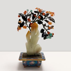 Op de afbeelding: Een jade bonsaiboom met oranje en groene edelsteenbloemen in een blauwe en gouden emaille pot.