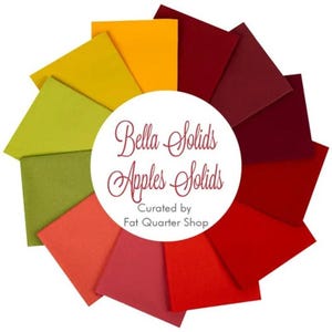 May include: A colourful arrangement of fabric squares in shades of red, orange, yellow, and green. The centre features a white circle with the text "Bella Solids Apples Solids" and "Curated by Fat Quarter Shop" in a burgundy script.