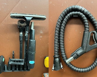 Vacuum accessory wall organizer with hose hanging adapter. Works with different attachments.