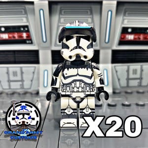 Puede incluir: Una minifigura LEGO en blanco y negro de un soldado clon de Star Wars con una visera azul. La minifigura lleva un casco y una armadura. El texto "X20" est&aacute; en primer plano.