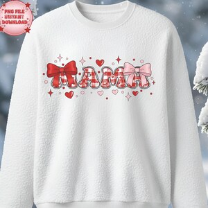 Peut inclure: Sweat-shirt en polaire blanc avec le mot "MAMA" en lettres à carreaux rouges et roses. Le motif comprend des nœuds, des cœurs et des étoiles rouges et roses. Le sweat-shirt a un col rond et une surface texturée.