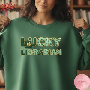 Peut inclure: Sweat-shirt vert avec l'inscription "LUCKY LIBRARIAN" en design 3D. Le mot "LUCKY" est orné de trèfles. Le sweat-shirt a un col rond et des manches longues. L'image comprend également un tampon "TÉLÉCHARGEMENT INSTANTANÉ".