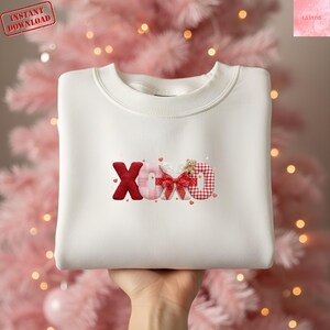 Peut inclure: Un sweat-shirt blanc avec les lettres "XOXO" en rouge, rose et motifs vichy. Un petit ours en peluche est sur la lettre "D". Le sweat-shirt a un col rond et est sur le thème de la Saint-Valentin. Les mots "Téléchargement instantané" sont dans le coin supérieur gauche.