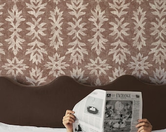 May include: A brown headboard and white bedding are in the foreground. The background features a brown and cream floral patterned wallpaper. A person is holding a newspaper with the headline "EXCHANGE". The text "APOSTROFO DESIGN" is at the bottom.