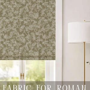 May include: A Roman shade featuring a dark olive green fabric with a white botanical print of delicate wildflowers and stems. The text APOSTROFO DESIGN is visible at the top, and the text FABRIC FOR ROMAN SHADES is visible at the bottom.